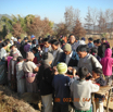 Food was being served for the guests in the open field over the table without chairs